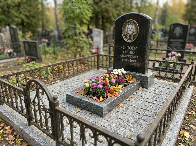 Благоустроенное захоронение с гранитной плиткой, оградой и цветником в Уфе