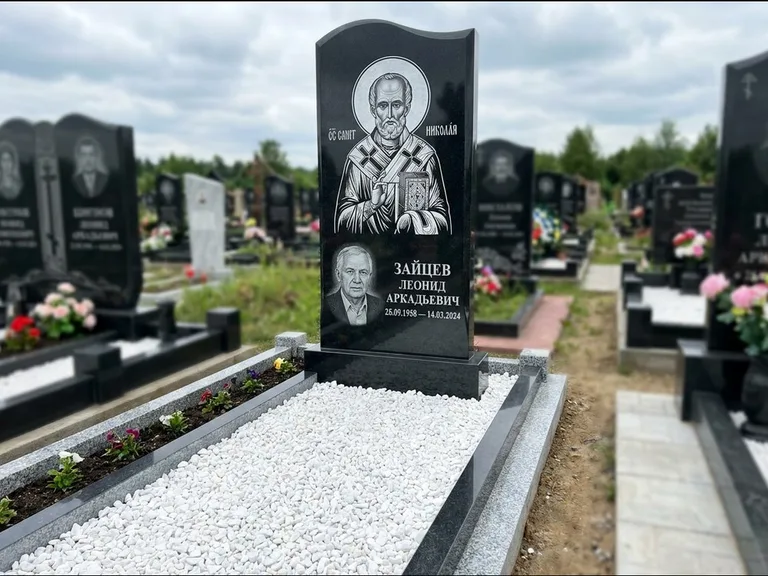 Памятник с гравировкой иконы: стела с крестообразным навершием — икона в резной рамке-киоте, газон без ограды, стриженая трава, работа «Раевская» в Уфе