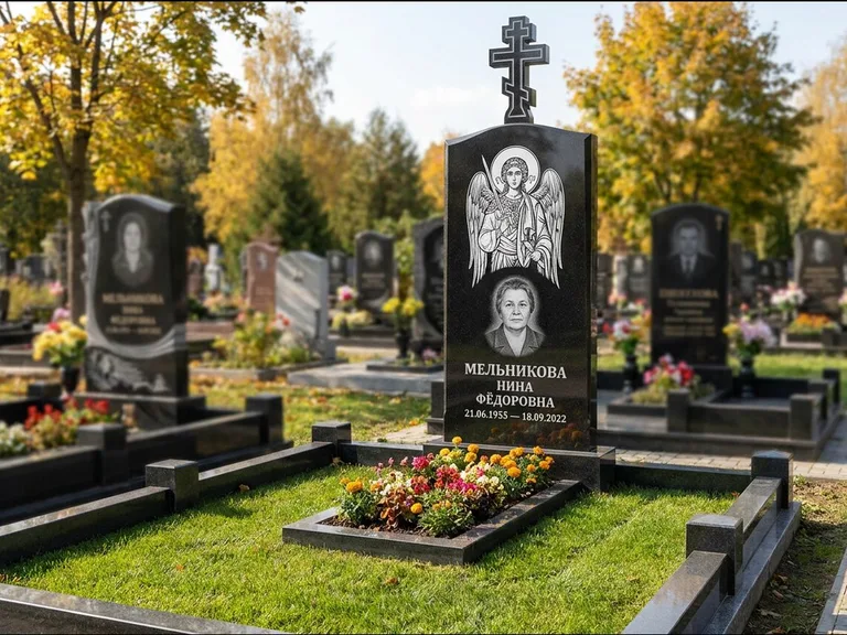 Памятник с гравировкой иконы: округлая стела-медальон с ликом — гравировка Богородицы «Семистрельная», луговые травы и полевые цветы за участком, работа «Гущин» в Уфе