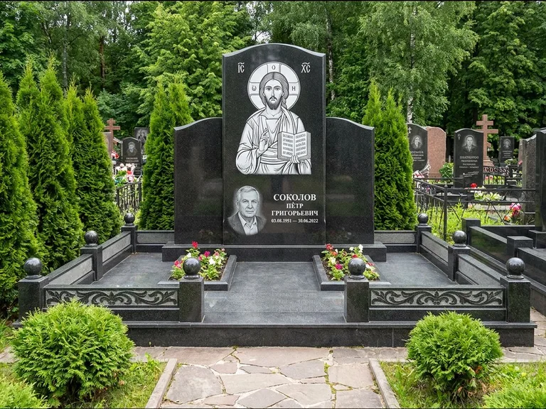 Памятник с гравировкой иконы: широкая горизонтальная лежачая плита-стела — икона в резной рамке-киоте, серая гравийная отсыпка с бордюром, работа «Богданова» в Уфе