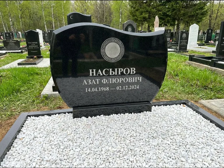 Мусульманский памятник: стела с волнообразным скошенным верхом — гравировка мечети под полумесяцем и звёздами, белая мраморная крошка с бордюром, работа «Насыров» в Уфе