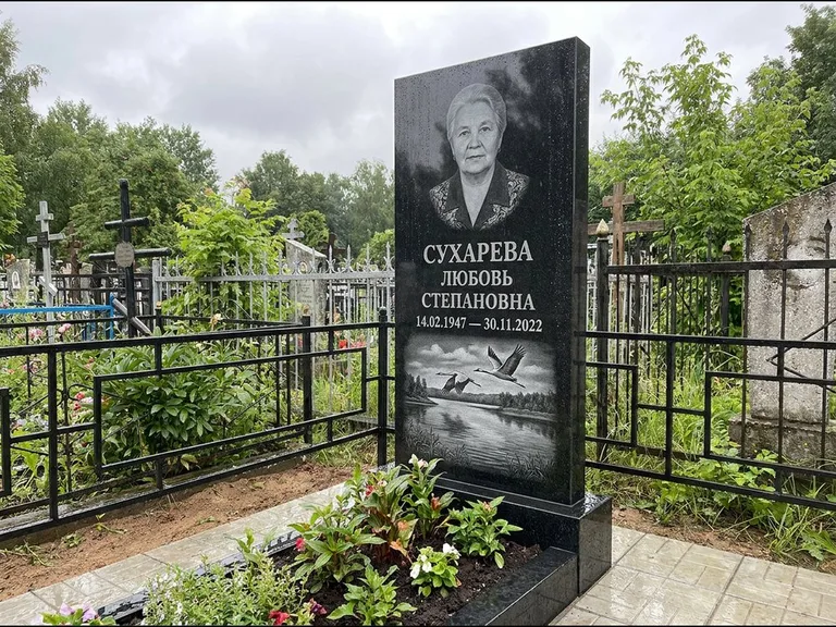 Памятник с гравировкой журавлей — гравировка пары журавлей над гладью озера в нижней части, работа «Сухарева» в Уфе